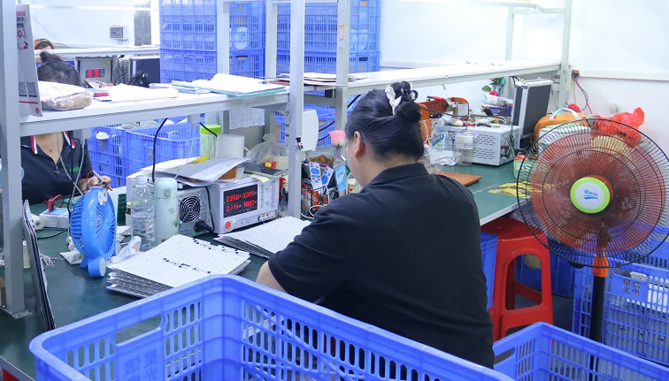 technician performing ceiling fan quality control inspection and testing in industrial factory laboratory ensuring product reliability before shipment