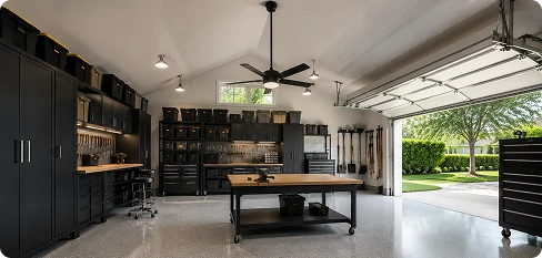 Downrod mount garage ceiling fan installed in a high ceiling workshop with organized storage and tools