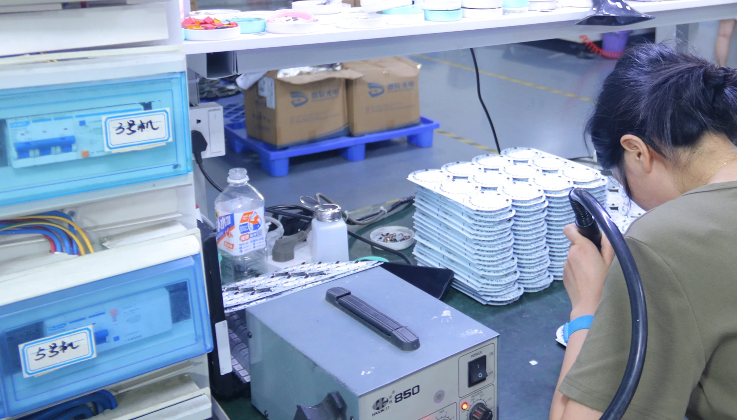 quality control process in ceiling fan factory showing technician testing electronic components for LED ceiling fan systems