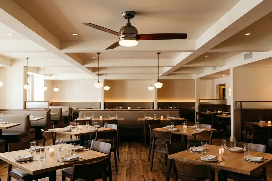 Quiet commercial ceiling fan with light installed above a modern restaurant dining area